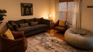 A cozy living room with a sofa, armchair, and bean bag. - Family-Friendly Smoky Mountain Retreat | Hot Tub (Sevierville)