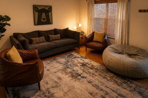 Ein gemütliches Wohnzimmer mit einer Couch, einem Sessel und einem Sitzsack.