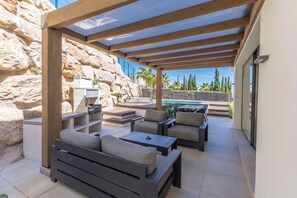 An outdoor patio with a pool, stone walls, and modern furniture. - House in Mijas • SeaViews • Pool • PrivateTerrace. (AN)