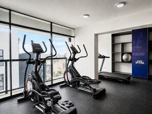 A gym with two elliptical machines, a treadmill, and a wall with a motivational poster. - Depa moderno Miraflores Gym parking 811 (Lima)
