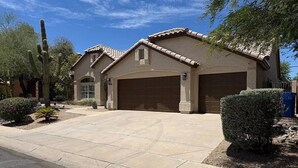 A residential house with a garage, a driveway, and a cactus in the yard. - Upscale Desert Oasis - Heated Pool - Golf (Scottsdale)