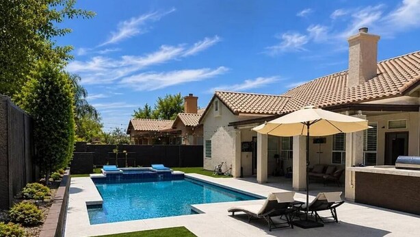 A backyard with a swimming pool, a lawn, and a patio area with outdoor furniture. - Upscale Desert Oasis - Heated Pool - Golf (Scottsdale)