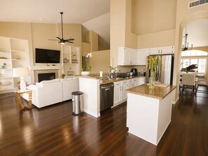 A modern kitchen with white cabinetry, a central island, and a built-in oven. - Upscale Desert Oasis - Heated Pool - Golf (Scottsdale)