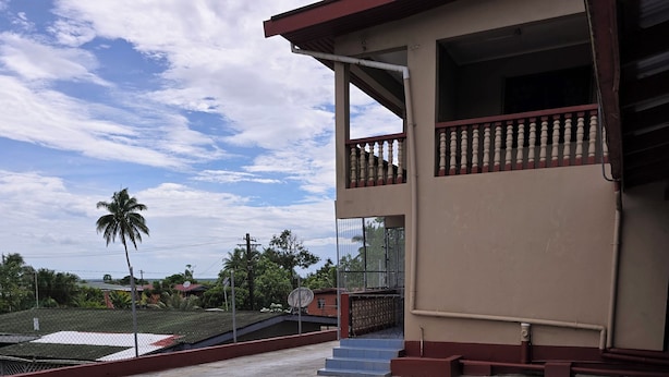 Un edificio con balcón y suelo de hormigón.