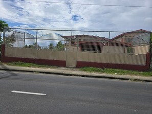 A gated residential area with a paved road in front.