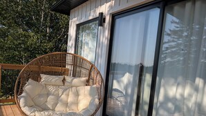 Ein Korbstuhl mit Kissen auf einer Terrassenfläche.