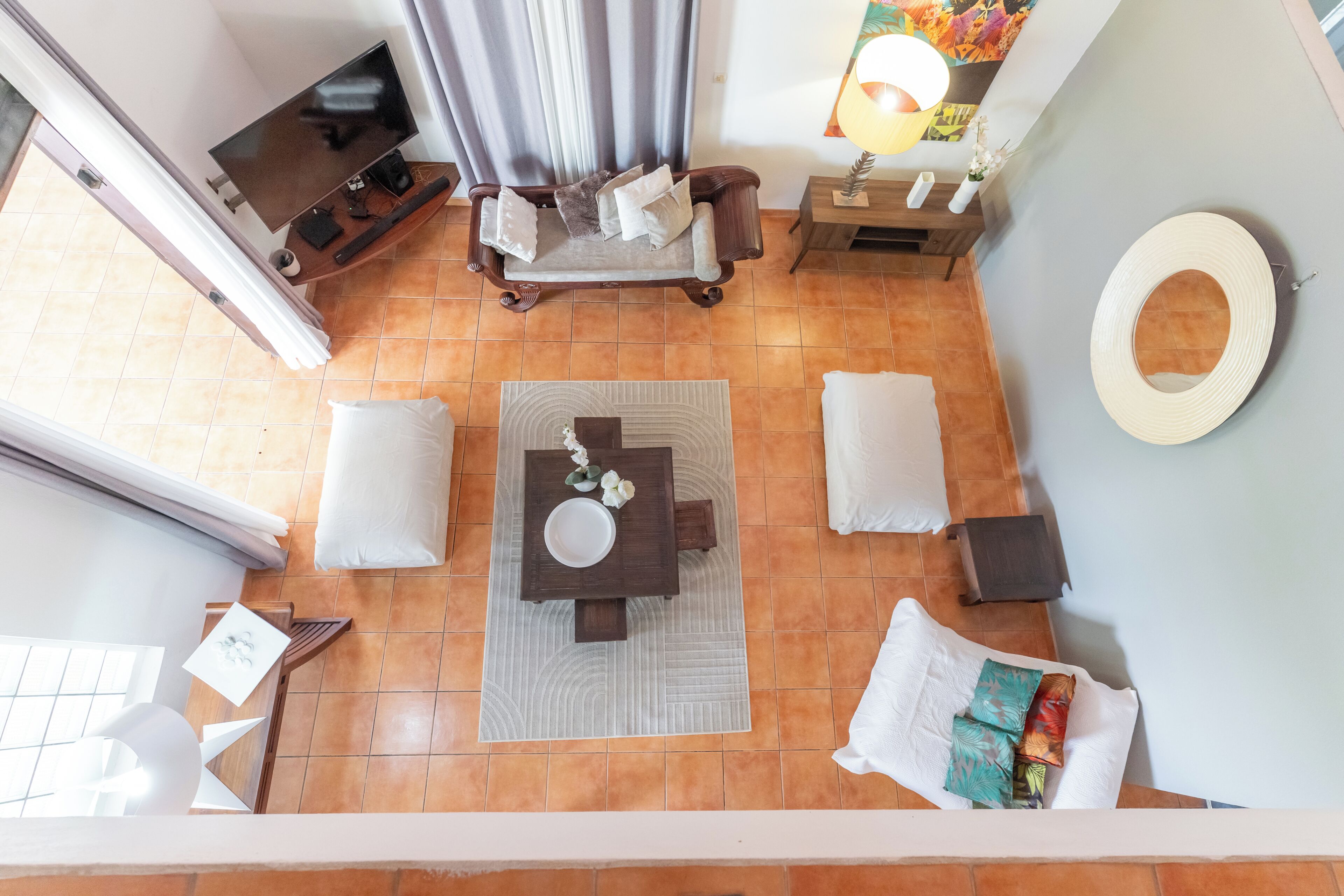 Una habitación con una cama, una mesa, una silla, una lámpara y un espejo.