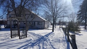 A snow-covered path leading to a house with a wooden fence and bare trees. - 4BR in Black Creek, near Green Bay Appleton, EAA, hunt, fish, raft, snowmobile (Black Creek)