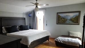 A bedroom with a bed, a desk, a chair, a ceiling fan, a window with curtains, and a painting on the wall. - 4BR in Black Creek, near Green Bay Appleton, EAA, hunt, fish, raft, snowmobile (Black Creek)