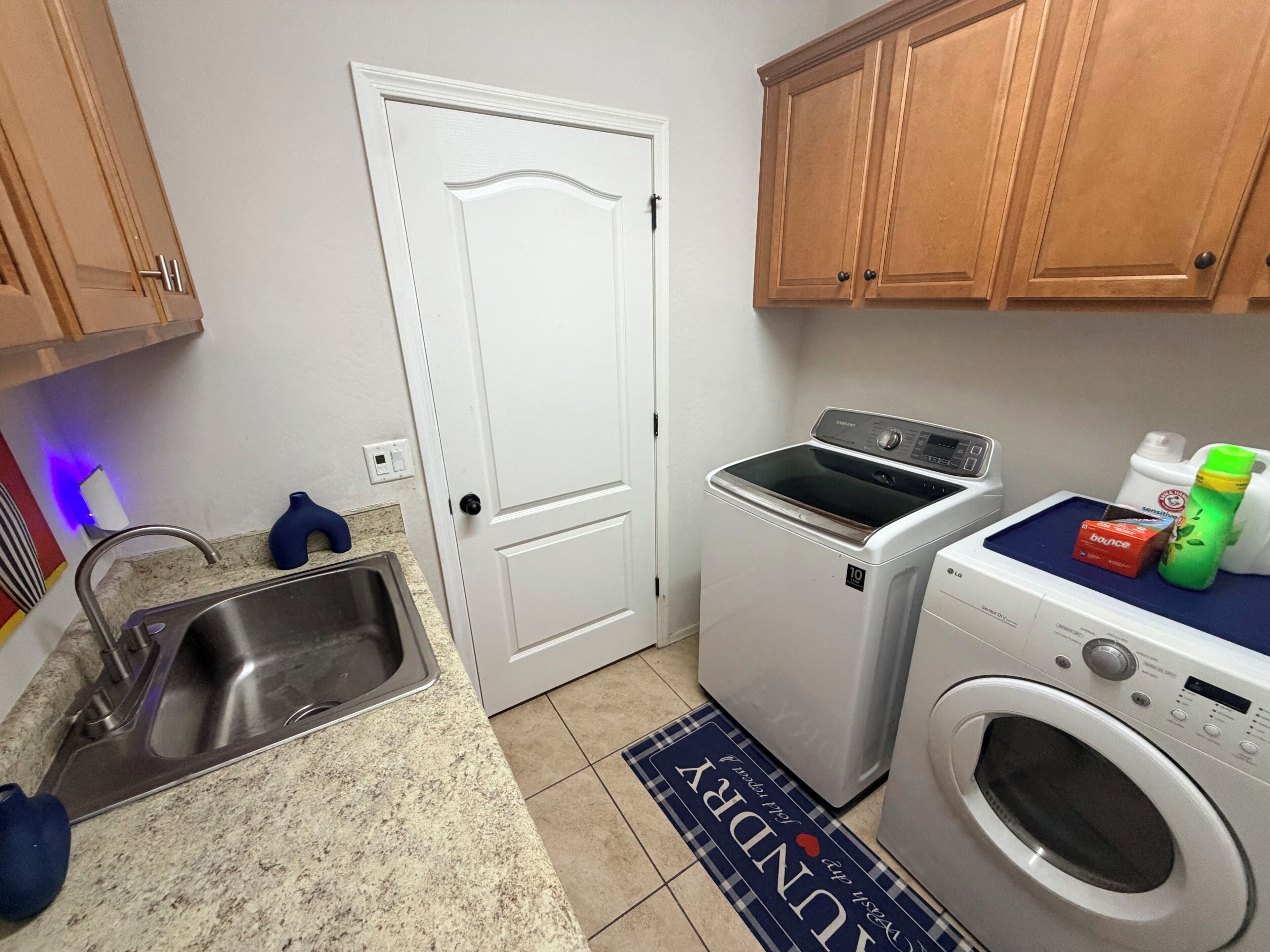 A laundry area with a washing machine, dryer, and a sink.