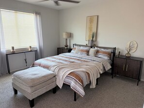 A bedroom with a bed, nightstands, a lamp, a vase, and a ceiling fan. - Spacious 3BR Home • Pet-Friendly • Near South Mountain & Downtown Phoenix (Phoenix)