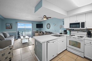 A modern kitchen with white cabinetry, a built-in oven, microwave, and a large island with a sink. - Gulf Front View + Beach Service + Pool + King Bed (Gulf Shores)