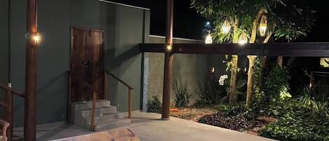 An outdoor patio with wooden benches and a hanging light fixture.