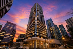 A high-rise building with multiple floors, large windows, and a modern architectural design. - Modern 22nd Floor 1BR | South-Facing City Views | Indoor Parking | North York (Toronto)