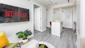 Ein modernes Interieur mit einem großen Netflix-Poster, einer Küchenzeile und einem Essbereich.