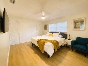 A bedroom with a bed, bedside table, chair, and a ceiling fan. - Incredible 5-bedroom POOL Home Next Universal/Parks (Orlando)