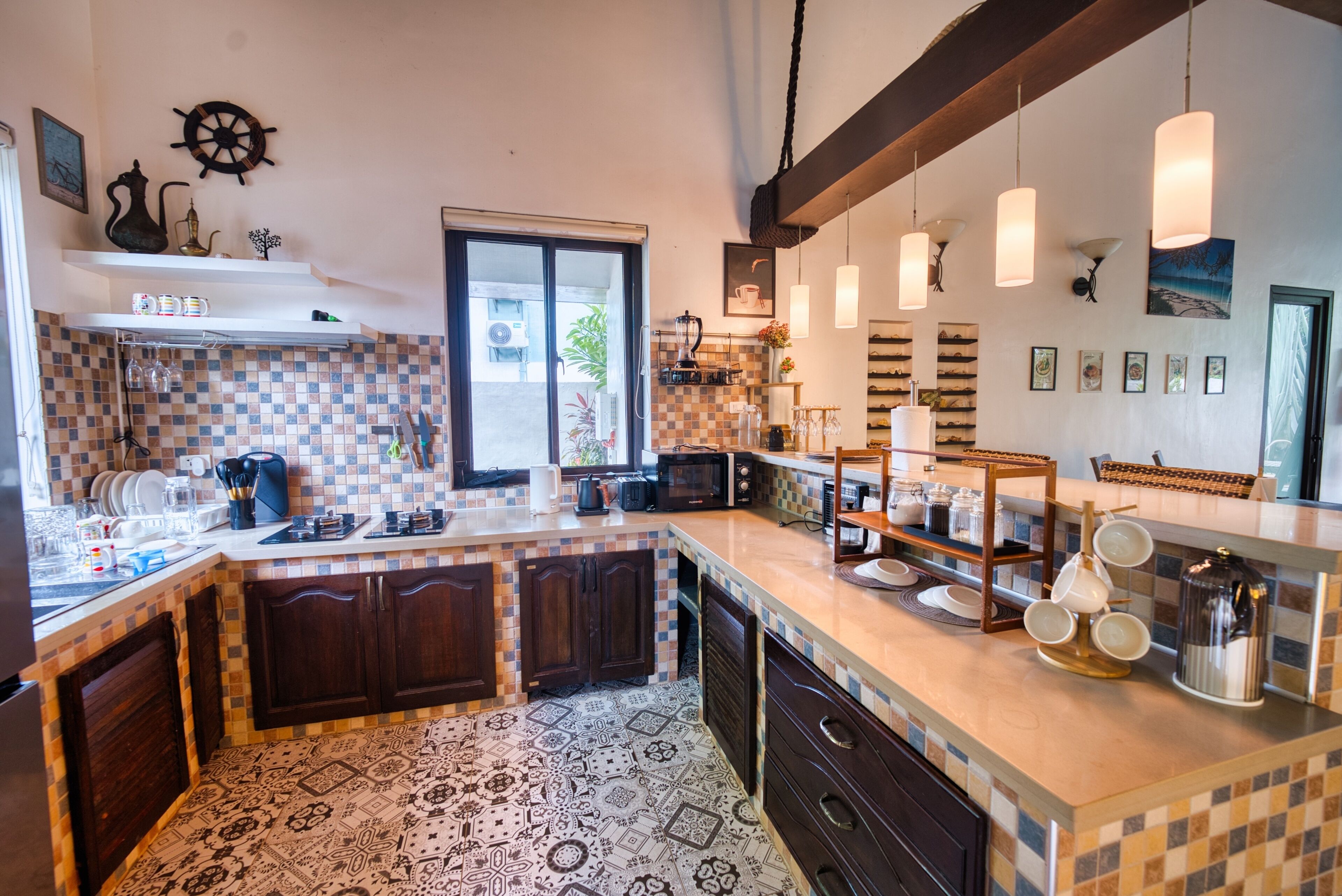 A kitchen with a tiled backsplash, wooden cabinets, a large window, and pendant lighting.