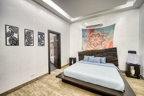 Une chambre à coucher avec un lit, une grande tapisserie et trois œuvres d’art mural.