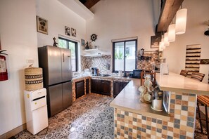A kitchen with a refrigerator, stove, and various kitchen appliances.