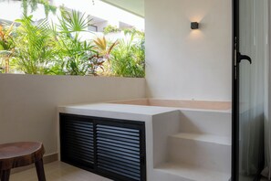 A modern bathroom with a built-in bench, a shower area, and a view of a garden with various plants. - Elements 326/Studio with Jacuzzi 234/ Beach club access included (Tulum)