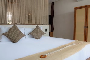 A neatly made bed with two pillows, a wooden headboard, and a woven curtain above. - Elements 326/Studio with Jacuzzi 234/ Beach club access included (Tulum)