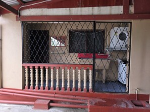 A gated entrance with a metal fence and a red and white balustrade.