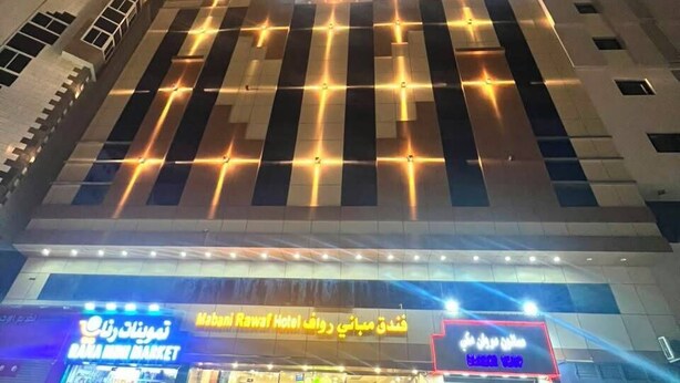 Un edificio de varios pisos con locales comerciales en la planta baja, incluyendo un mercado y un hotel.