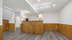 A room with a wooden partition, two lamps, and a door leading to another room.
