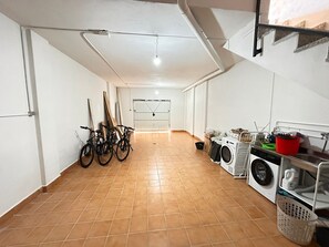 A laundry room with a washing machine, dryer, and stacked laundry baskets. - Vistas Rio Verde, Stunning unobstructed views of the valley with 3 terraces! (Almuñécar)