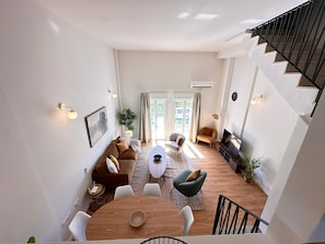A spacious living area with a staircase, a dining table, sofas, and a TV. - Vistas Rio Verde, Stunning unobstructed views of the valley with 3 terraces! (Almuñécar)