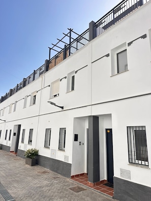 A multi-story residential building with a white facade, multiple windows, and a balcony with a metal railing. - Vistas Rio Verde, Stunning unobstructed views of the valley with 3 terraces! (Almuñécar)