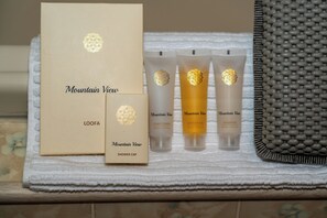 Een badkamer met een douchemuts, conditioner, douchegel en shampoo van Mountain View.