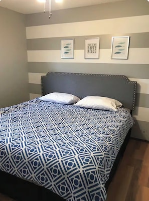 A bed with a patterned bedspread, a headboard, and two pillows. - Angler’s Basecamp | Last Mountain Cabin w/ Ample Boat & Trailer Parking (Dilke)