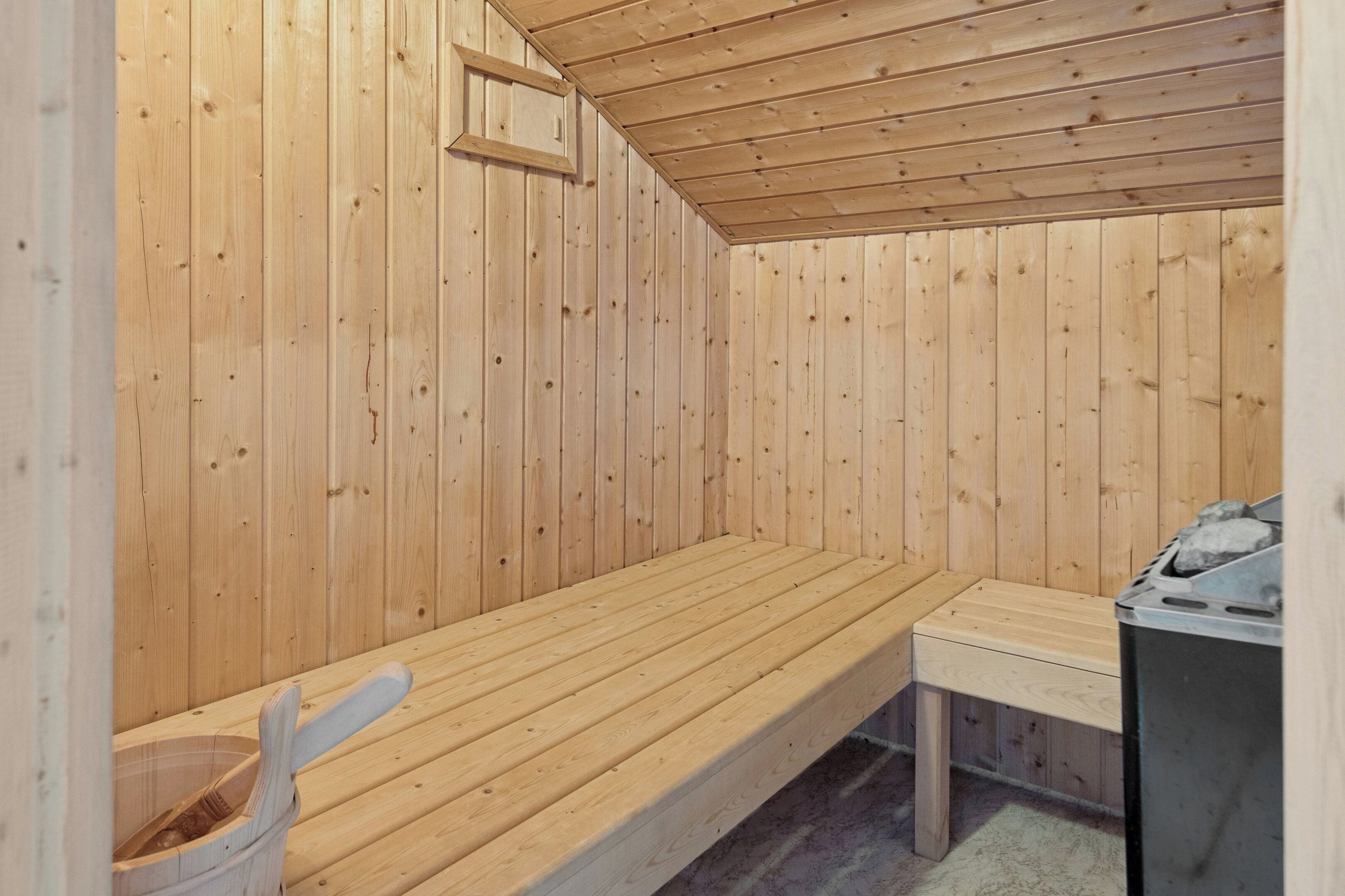 A sauna room with wooden walls and a bench.