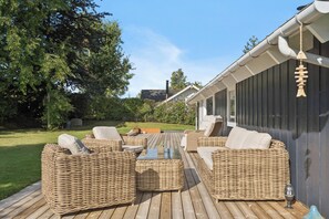 An outdoor seating area with wicker furniture and a wooden deck. - Lovely, well-designed holiday home for 6 (Hejls)
