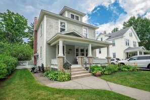 A two-story house with a front porch, a driveway, and a lawn. - NEW! Prelaunch Pricing Close to Track and Downtown (Saratoga Springs)