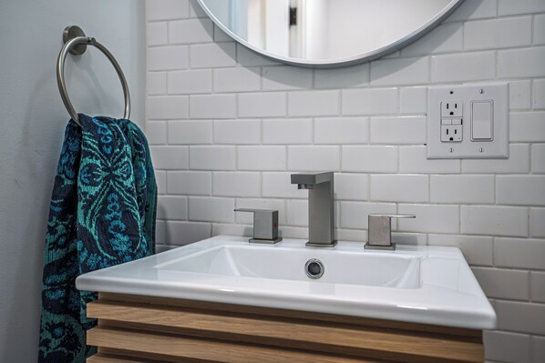 A bathroom with a white sink, a mirror, and a towel rack. - NEW! Prelaunch Pricing Close to Track and Downtown (Saratoga Springs)