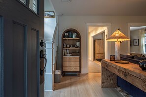 A hallway with a wooden bench, a bookshelf, and a lamp. - NEW! Prelaunch Pricing Close to Track and Downtown (Saratoga Springs)