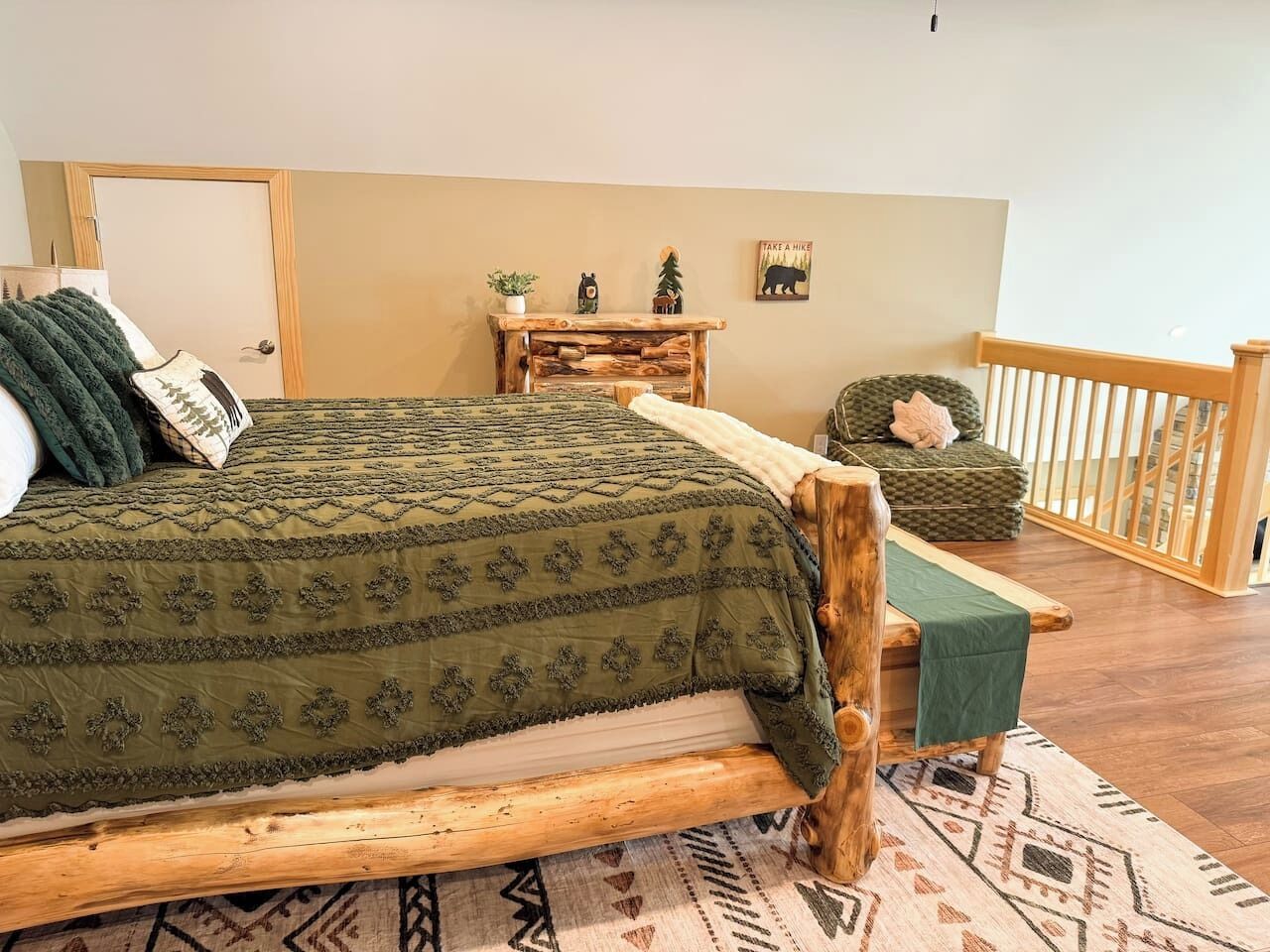 A room with a bed, a small table, a chair, and a view of a balcony.