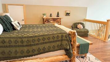 A room with a bed, a small table, a chair, and a view of a balcony.