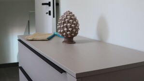 Una habitación con un aparador blanco, una decoración con piña y un dibujo de un pez azul en la pared.