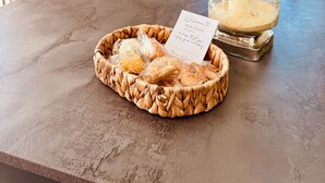 Una cocina con microondas, cafetera y ventana con persianas.