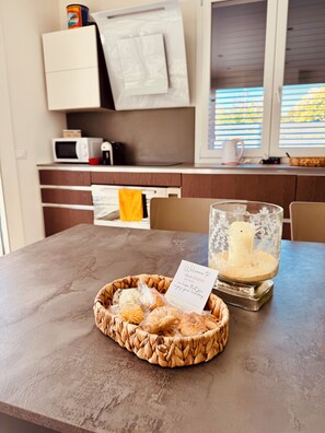 A kitchen with a microwave, a coffee maker, and a window with blinds. - Villa Zagara, a villa with a pool where families and friends can relax (Piane Vecchie)