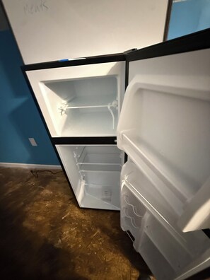 An open refrigerator with two shelves and a freezer compartment. - 2-bedroom house in tranquil Albrightsville perfect for relaxing getaway (Albrightsville)