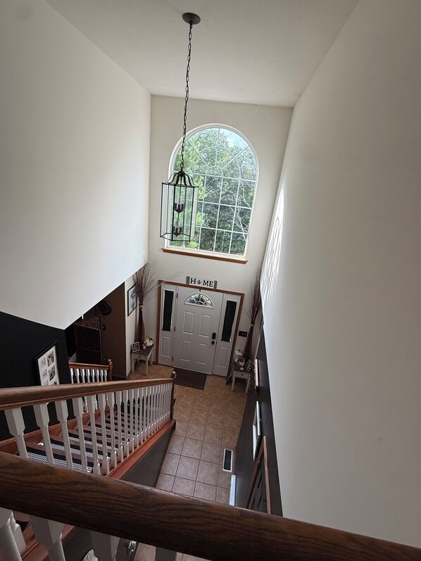 A staircase leading to a landing with a large arched window above a door labeled 'HOME'.