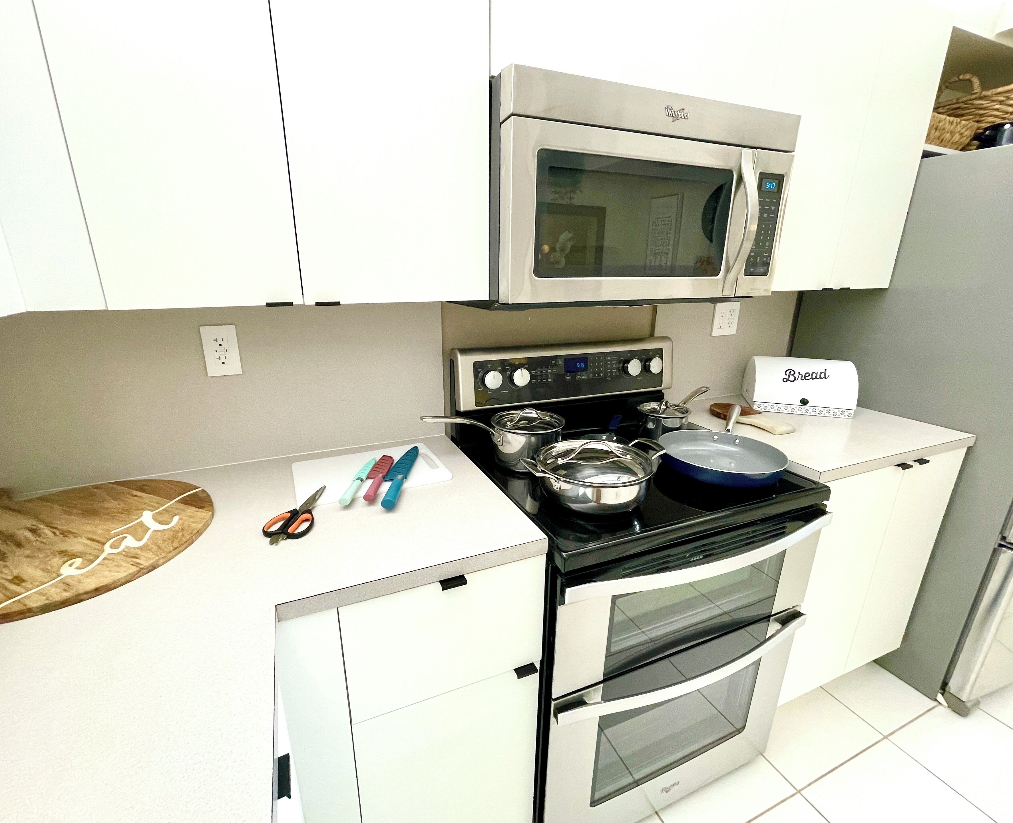Una cocina compacta con microondas, estufa y horno.