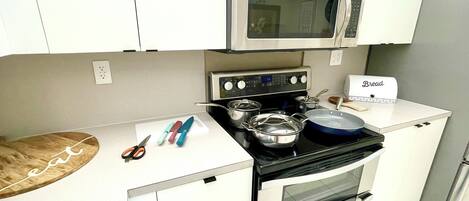 Una cocina compacta con microondas, estufa y horno.