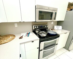 A compact kitchen with a microwave, stove, and oven. - Beachfront Paradise - Ocean Views + Free Parking (Hollywood)