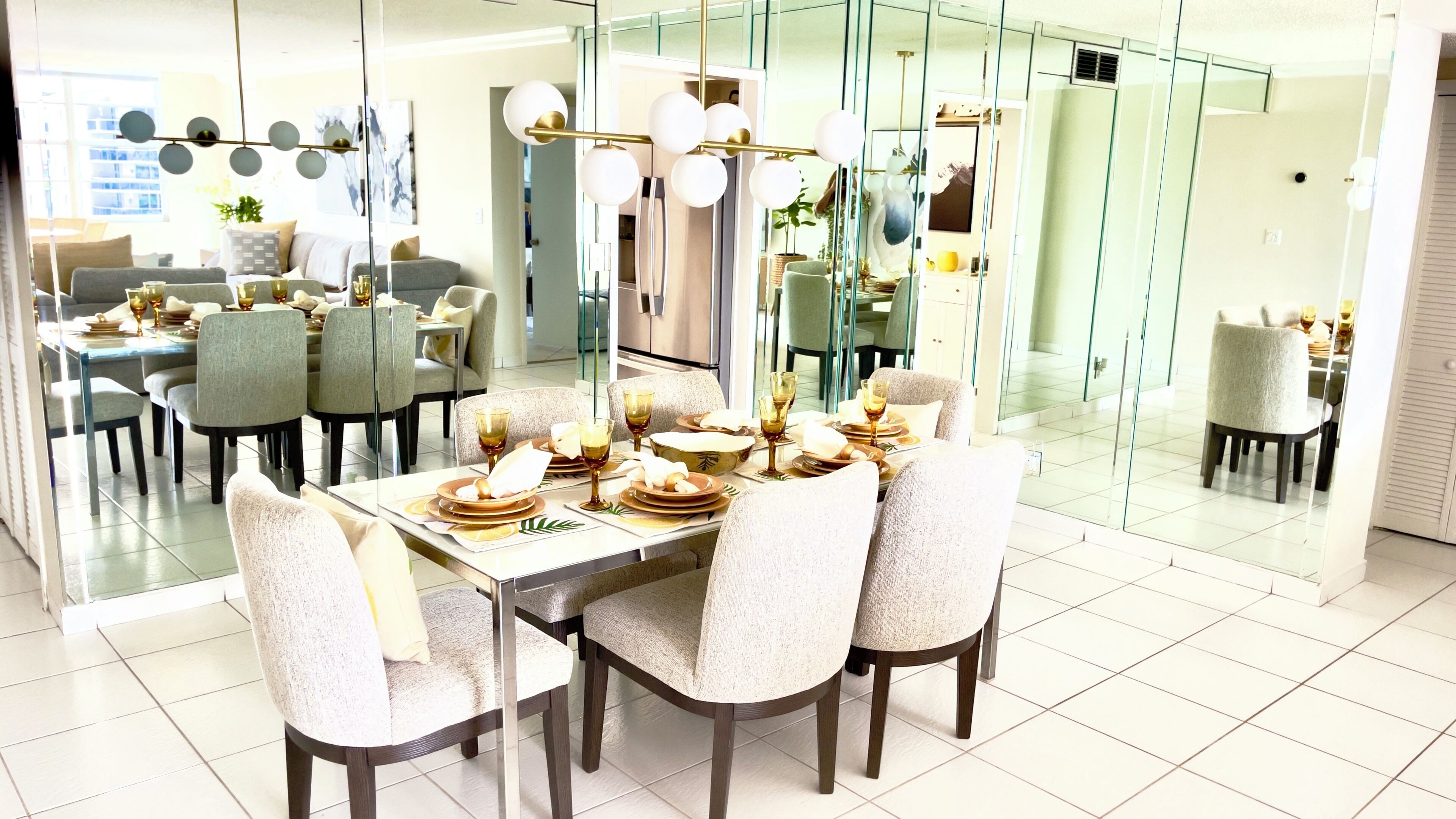 A modern dining area with a glass partition, a long table set for a meal, and a view of the adjacent living space.