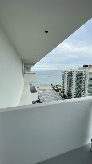 A balcony with a view of the ocean and adjacent buildings. - Beachfront Paradise - Ocean Views + Free Parking (Hollywood)